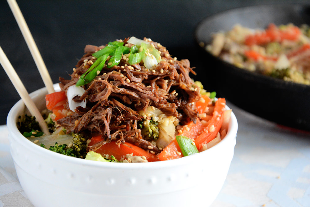 Asian beef simmered in the slow cooker until tender and served over low-carb cauliflower fried rice!