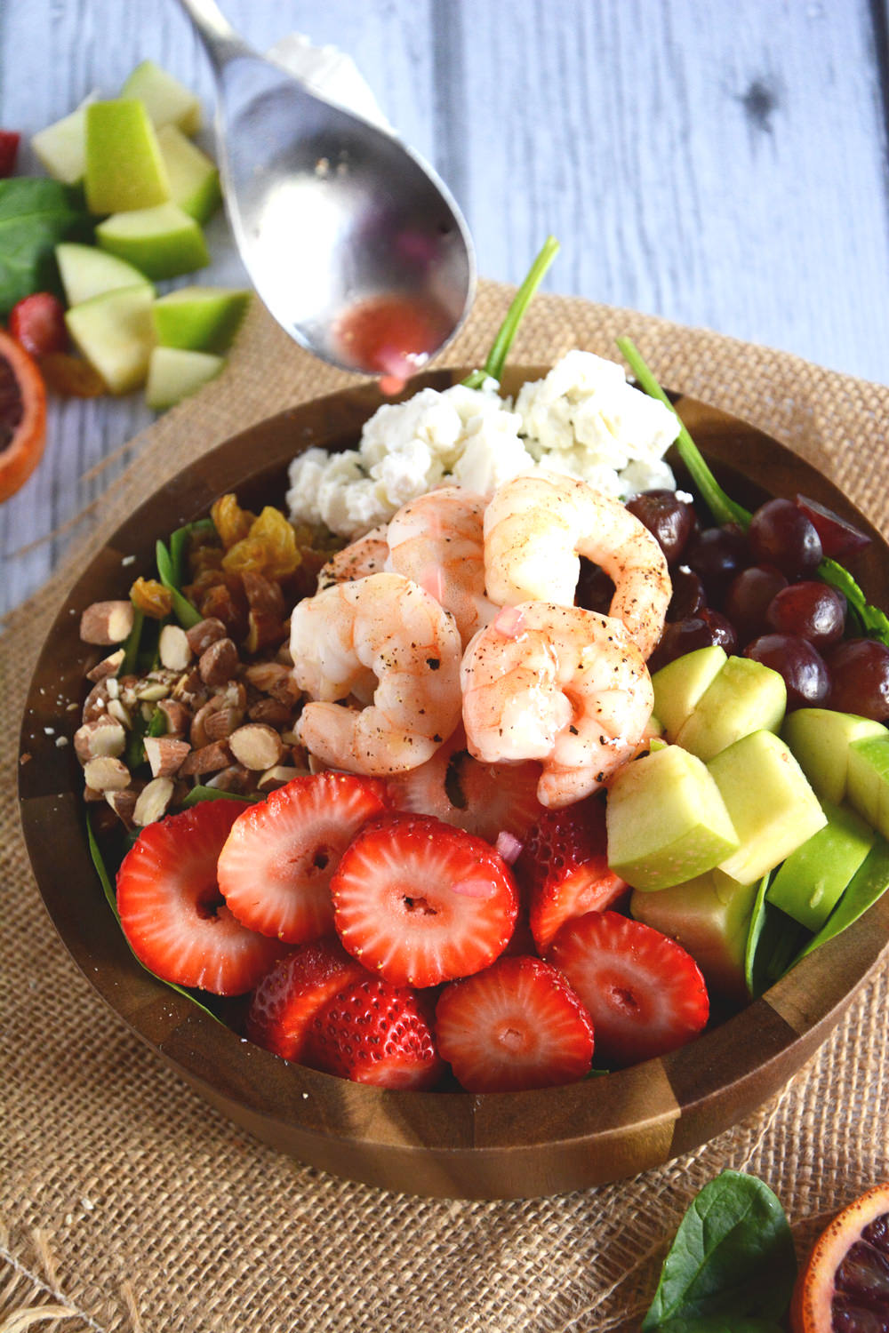 A vibrant salad with roasted shrimp, packed with fresh fruit, creamy goat cheese and roasted almonds and topped with a sweet citrus dressing made from blood oranges and sweetened with honey. This salad is colorful, healthy, and delicious!