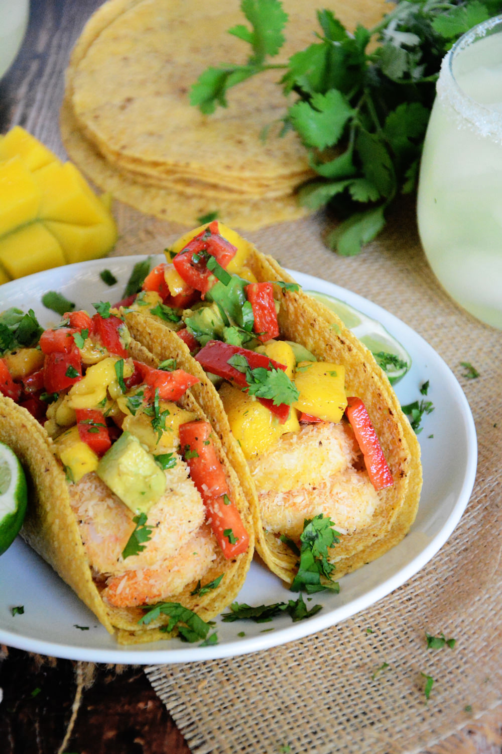 Healthy and Quick Shrimp Tacos sweetened with coconut and topped with a sweet and spicy salsa of mango, red pepper and avocado! 
