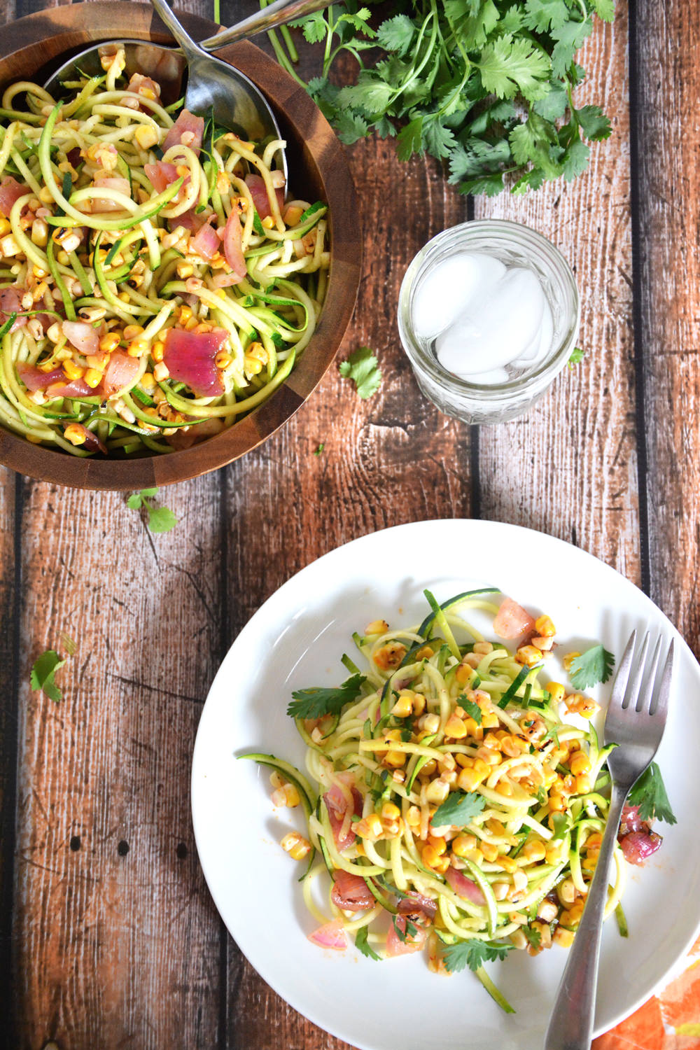 Roasted corn is paired with spiraled zucchini, red onion & tossed with a simple chili lime vinaigrette for a fresh, make ahead, summer roasted corn salad!