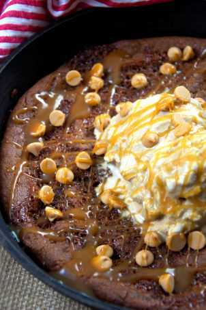A flourless peanut butter cookie, filled with caramel and topped with caramel ice cream is an incredible skillet dessert that is ready in under 30 minutes! #peanutbuttercookie #glutenfree #dessert