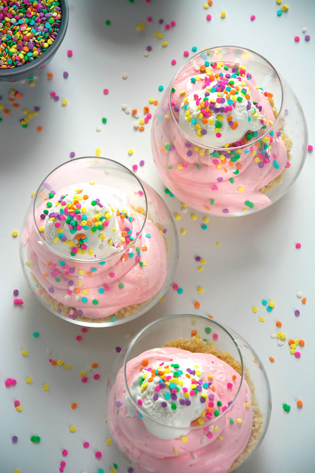 An easy, no bake cake batter cheesecake is healthy and simple to make with greek yogurt, low fat cream cheese, sprinkles and a buttery sugar cookie crust! 