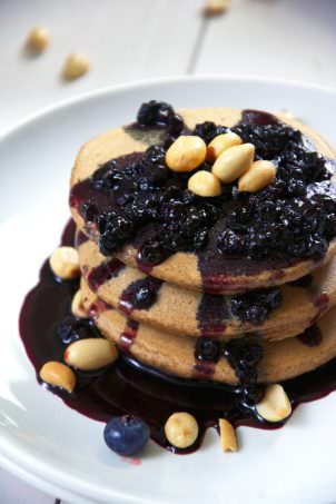 Pure grown up, peanut butter and jelly bliss right here with oat pancakes filled with greek yogurt and honey roasted peanut butter and topped with a simple two ingredient blueberry glaze!