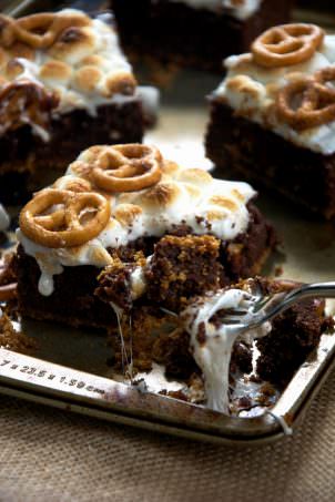 S'mores get an update with these Toasted Marshmallow Brownies as they are made healthier with oats, applesauce, two types of chocolate and then sit on top of cinnamon sugar pretzels! #smores #brownies #marshmallows #glutenfree