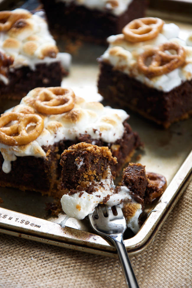 S'mores get an update with these Toasted Marshmallow Brownies as they are made healthier with oats, applesauce, two types of chocolate and then sit on top of cinnamon sugar pretzels! #smores #brownies #marshmallows #glutenfree