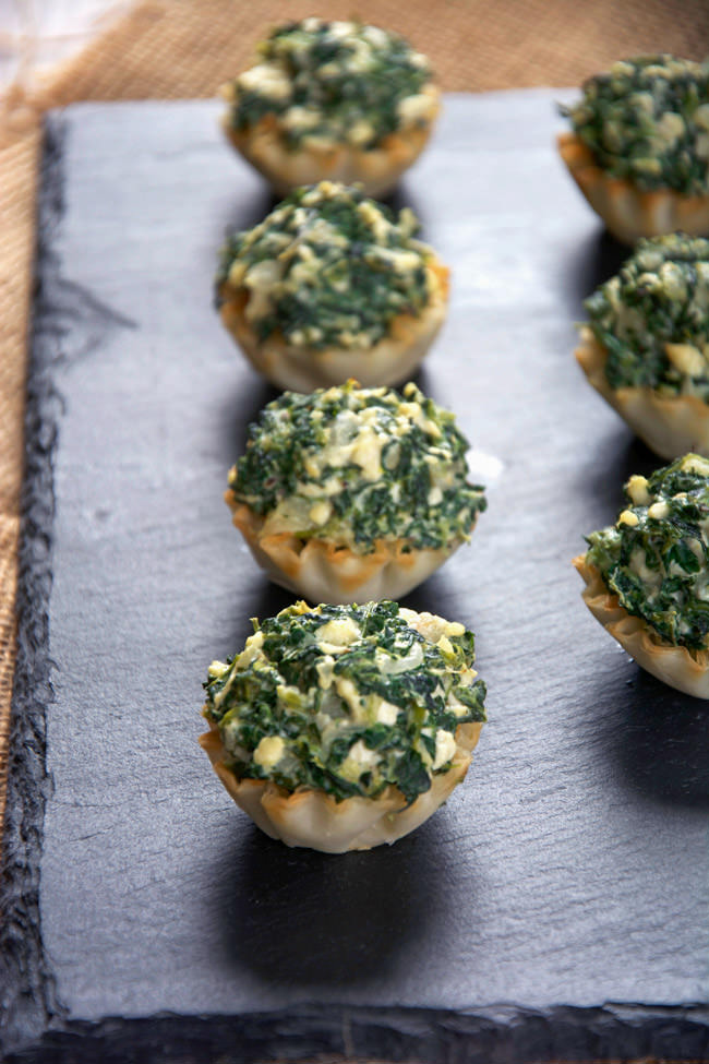 Mini tarts pays homage to the classic Spanakopita! These fool proof Creamy Spanakopita Tarts fill mini phyllo tarts with a lighter spinach and feta filling. They will be they hit at any party!