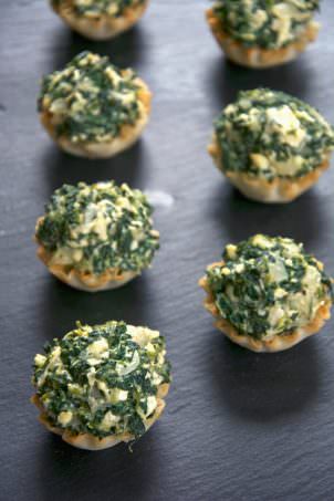 Mini tarts pays homage to the classic Spanakopita! These fool proof Creamy Spanakopita Tarts fill mini phyllo tarts with a lighter spinach and feta filling. They will be they hit at any party!