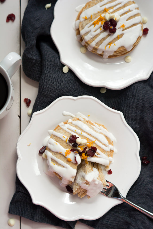 A Starbucks inspired breakfast, Whole Wheat Cranberry Bliss Pancakes are orange scented, studded with dried cranberries, filled with white chocolates and drizzled in a greek yogurt glaze!