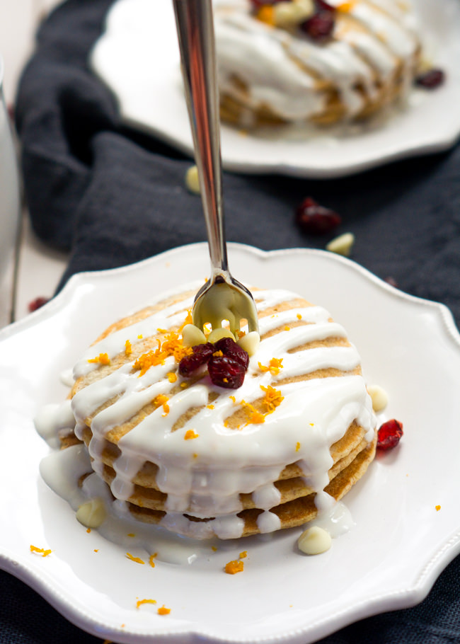 A Starbucks inspired breakfast, Whole Wheat Cranberry Bliss Pancakes are orange scented, studded with dried cranberries, filled with white chocolates and drizzled in a greek yogurt glaze!