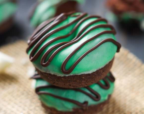 Your favorite Girl Scout Cookie just took over breakfast in these Mini Thin Mint Donuts! Tender chocolate donuts covered with mint white chocolate icing and a chocolate drizzle!