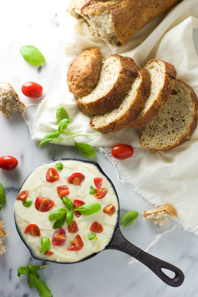 All the flavors of your favorite salad in an appetizer! Skinny Hot Caprese Dip is lighter thanks to a secret ingredient, greek yogurt, gooey mozzarella, tomatoes and fresh basil!