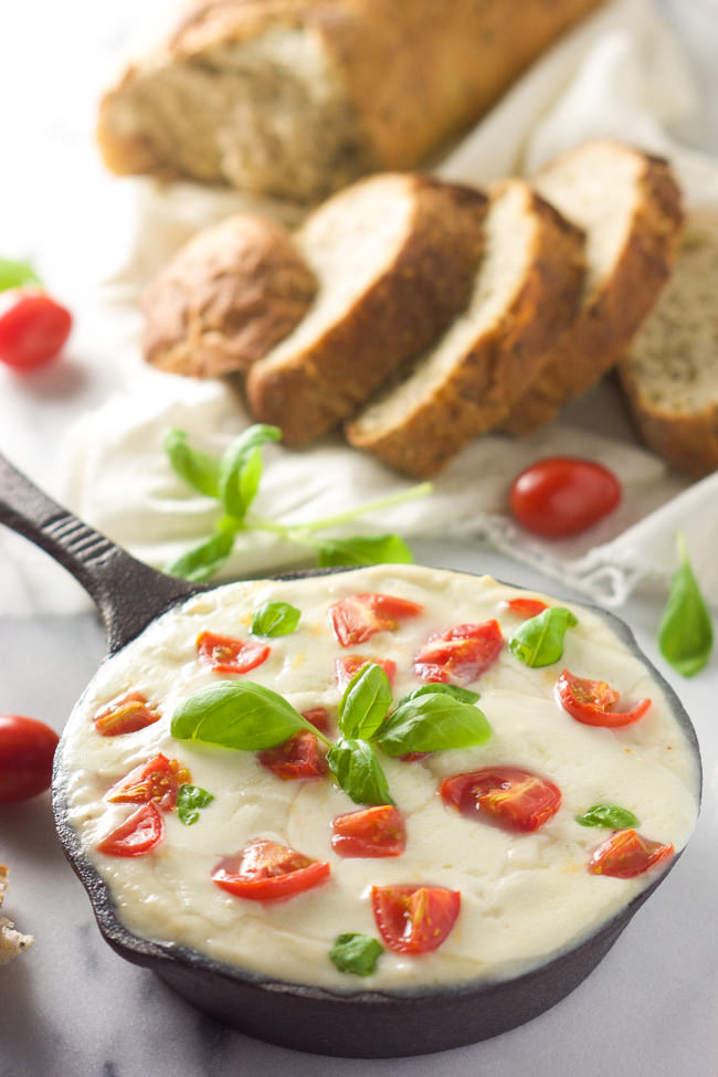 All the flavors of your favorite salad in an appetizer! Skinny Hot Caprese Dip is lighter thanks to a secret ingredient, greek yogurt, gooey mozzarella, tomatoes and fresh basil!