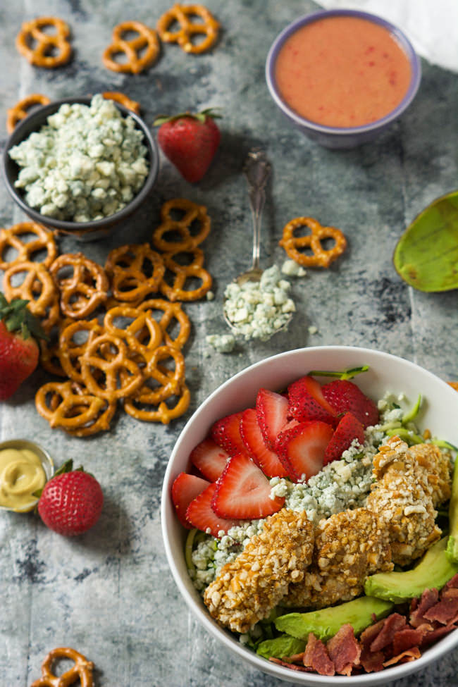 A fresh and summery salad that is slightly sweet and spicy all in the same bite! This Strawberry & Honey Mustard Pretzel Chicken Cobb Salad will step up your dinner time salad in no time!