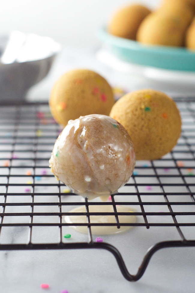 An easy, one bowl birthday cake in the form of donuts! Baked Vanilla Funfetti Donut Holes bake quickly and filled with sprinkles!