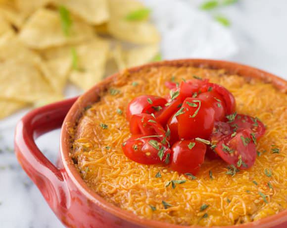This {Lightened Up} Chicken Enchilada Dip is a family favorite turned into a crowd pleaser! Bubbly and gooey cheese dip filled with taco-spiced chicken and greek yogurt to make it healthier!