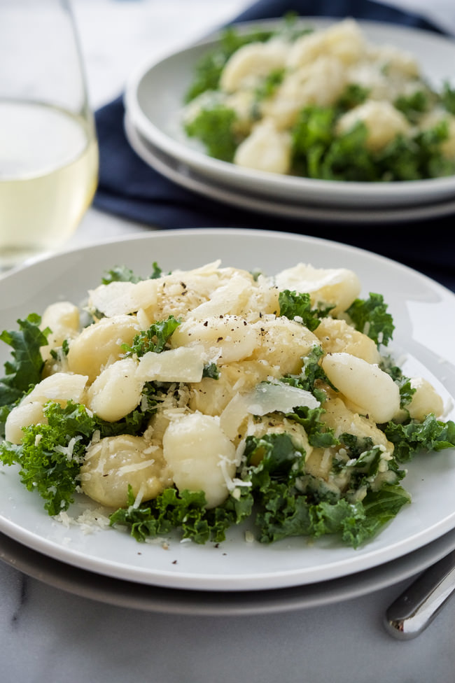 Creamy Garlic Parmesan Gnocchi is a comfort dish that is whipped up in only 15 minutes! Filled with tender gnocchi and kale, then smothered in a light garlic parmesan sauce!