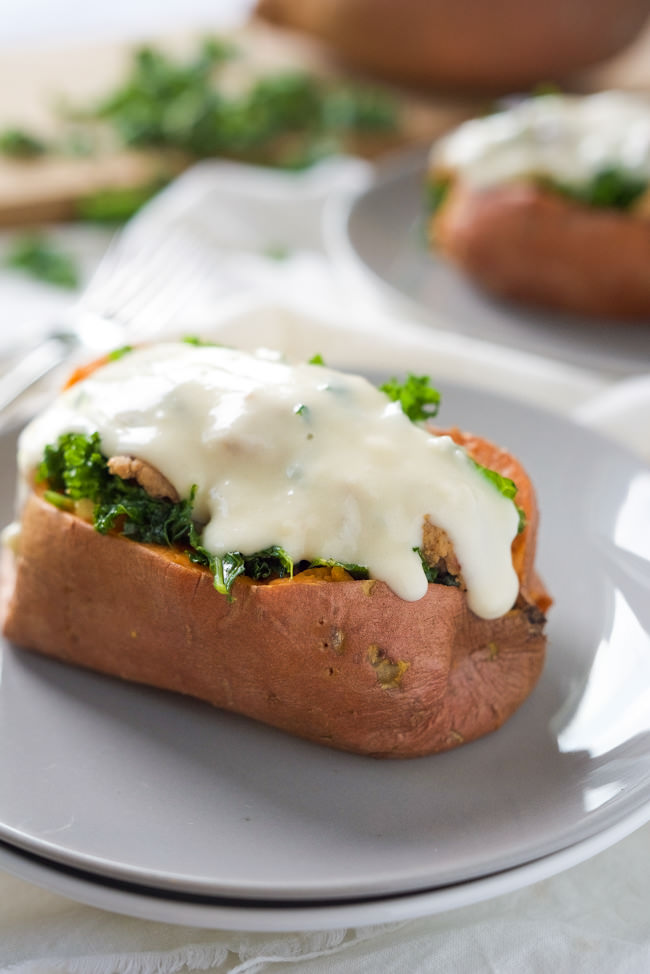 Kale and Sausage Stuffed Sweet Potatoes are an easy dinner idea, filled with sweet sausage and smothered in an easy white cheese sauce! 