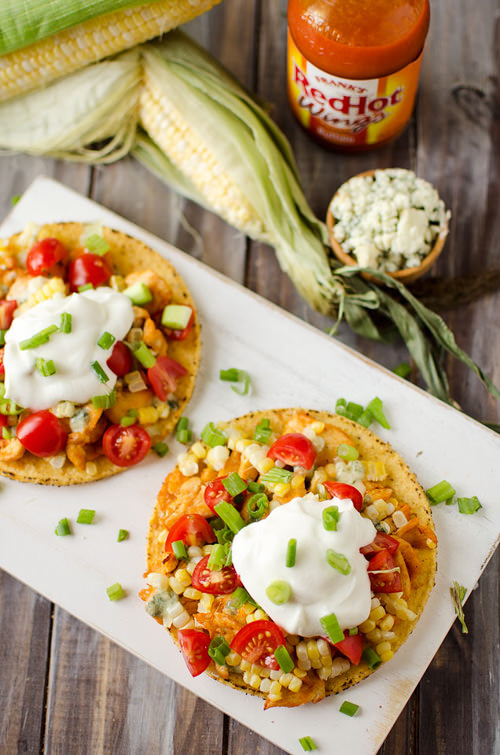 These Buffalo Chicken & Sweet Corn Tostadas are loaded with bold flavors from buffalo chicken, creamy bleu cheese and crunchy sweet corn and green onions!