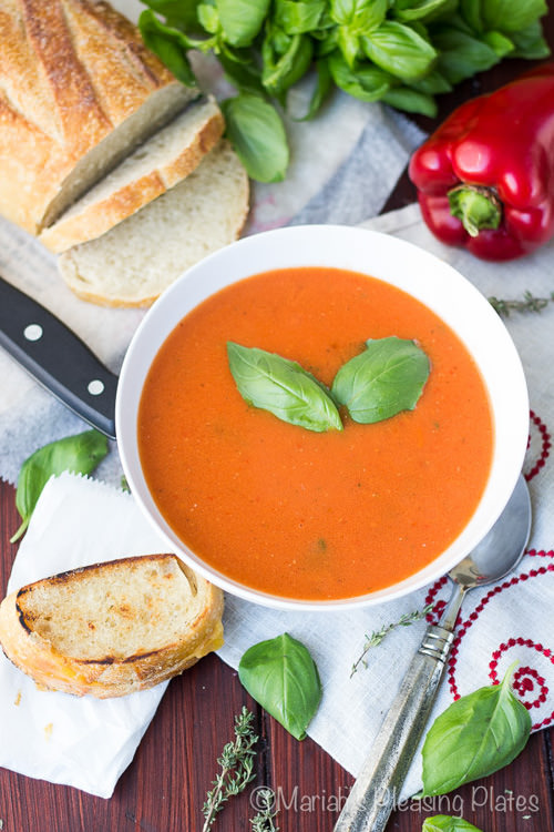 Easy Roasted Red Pepper and Tomato Soup filled with fresh herbs, fire roasted tomatoes, garlic and a splash of cream, this truly is the best tomato soup ever! The best part is that it only takes 25 minutes to make and is the best for winter since it uses sweet canned tomatoes!