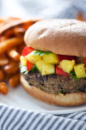 Take a bite out of these 20 Minute, homemade black bean burgers that come together with pantry items and topped with a sweet, pineapple salsa!