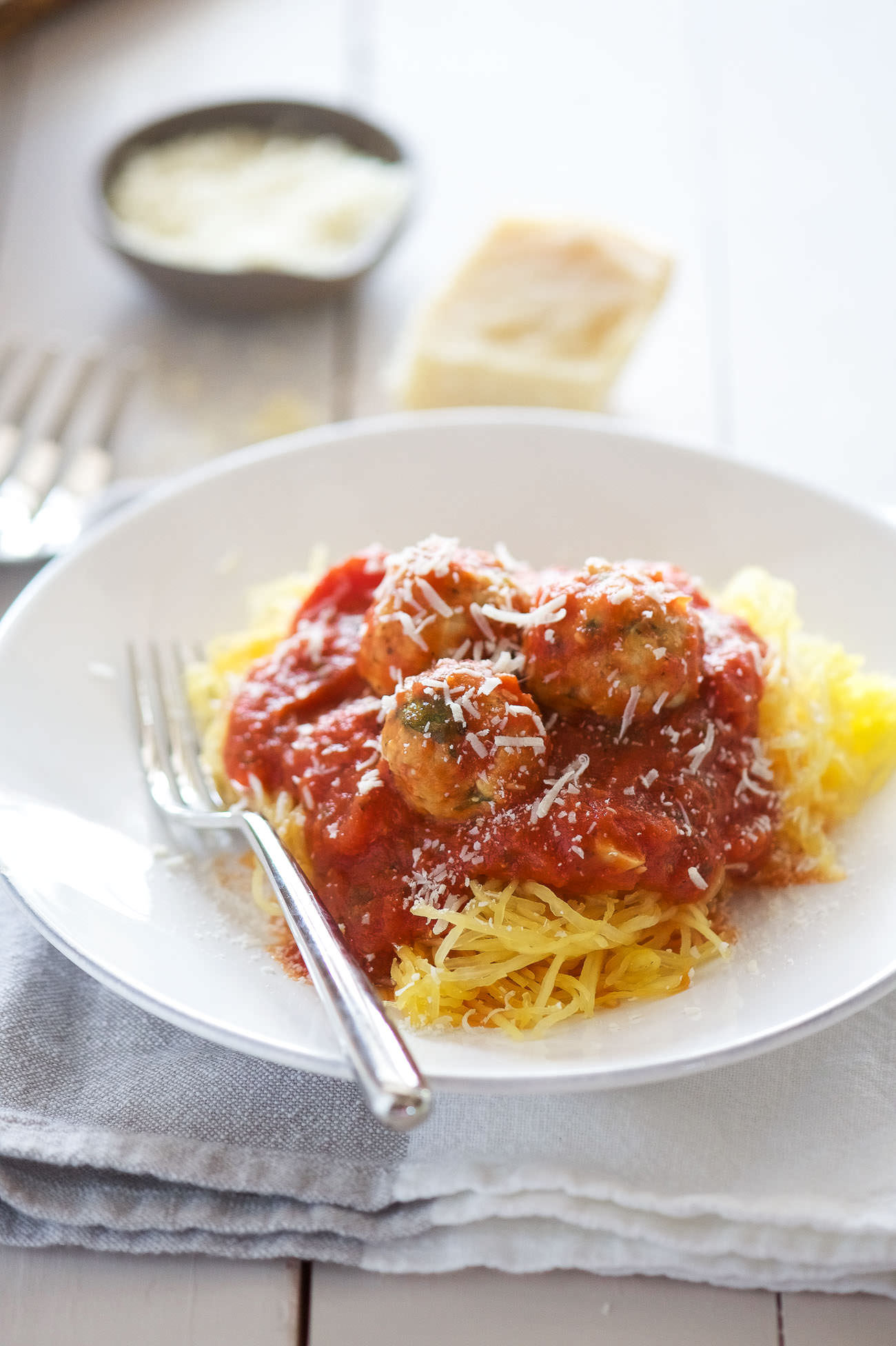 Skinny Sun Dried Tomato Meatballs with Spaghetti Squash are a light and flavorful way to cure your craving for spaghetti and meatballs! Lean ground turkey is mixed with sun dried tomatoes and spinach. Perfect to make ahead, freeze then bake before serving!