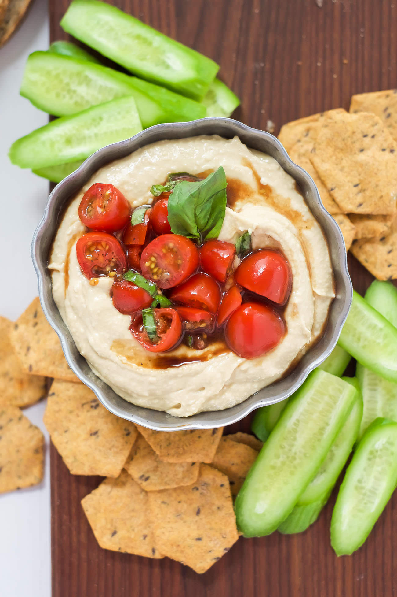 This 5 Minute Bruschetta Hummus is the ideal summer appetizer! The classic Italian flavors shine through with the homemade cherry tomato and garlic bruschetta that pairs perfectly with creamy hummus!
