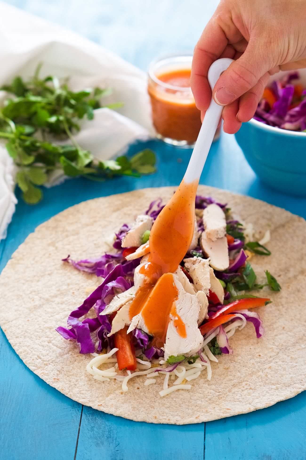 These Hot & Spicy Thai Chicken Wraps is the perfect quick dinner or lunch! Filled with a spicy thai slaw, grilled chicken, pepper jack cheese and drizzled with an addicting Sriracha honey aioli!