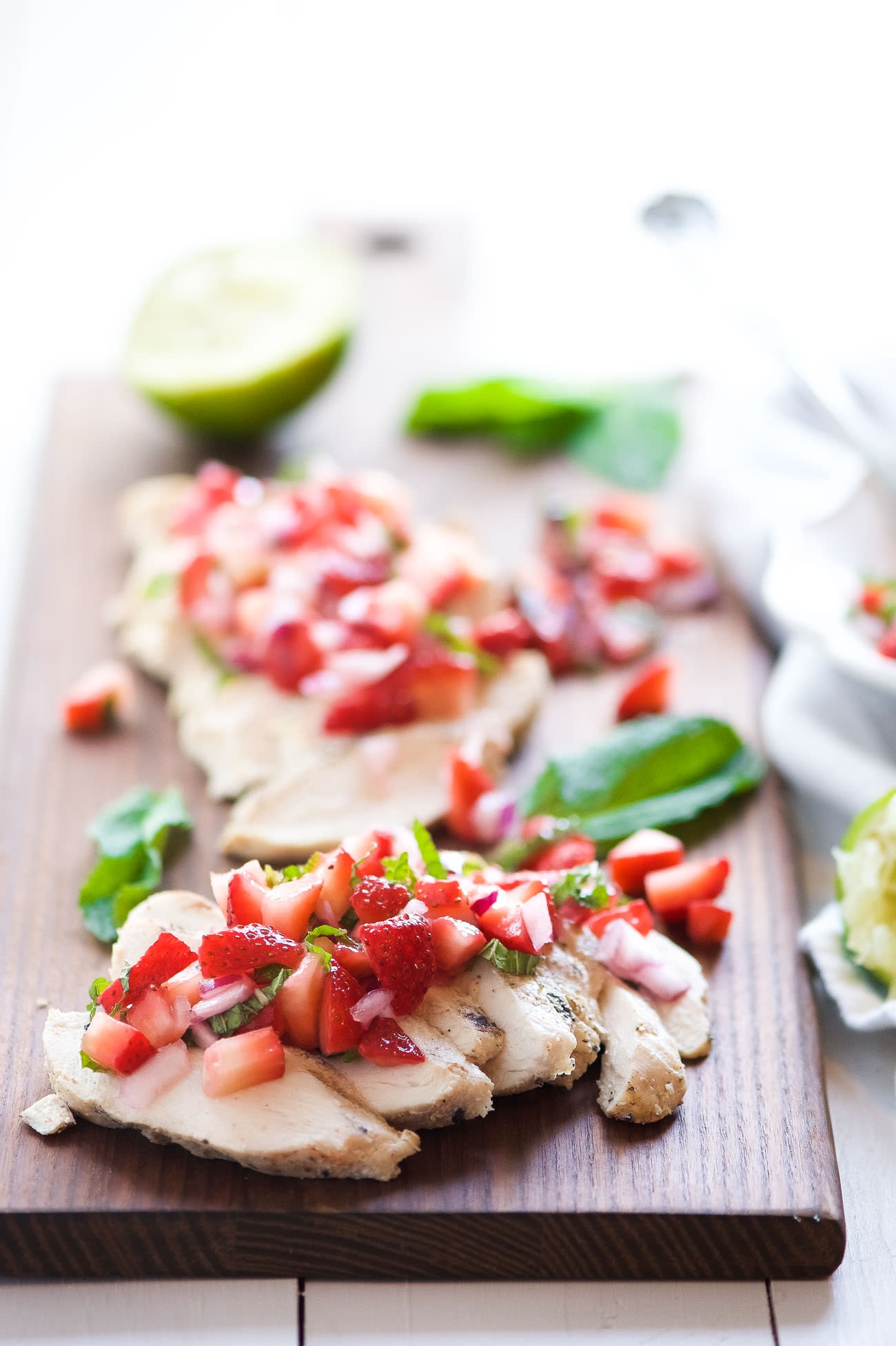 Balsamic Grilled Chicken with Strawberry Mint Salsa is a fresh spin on dinner! Fresh strawberries, mint and lime make the ideal summer topping for juicy grilled chicken!