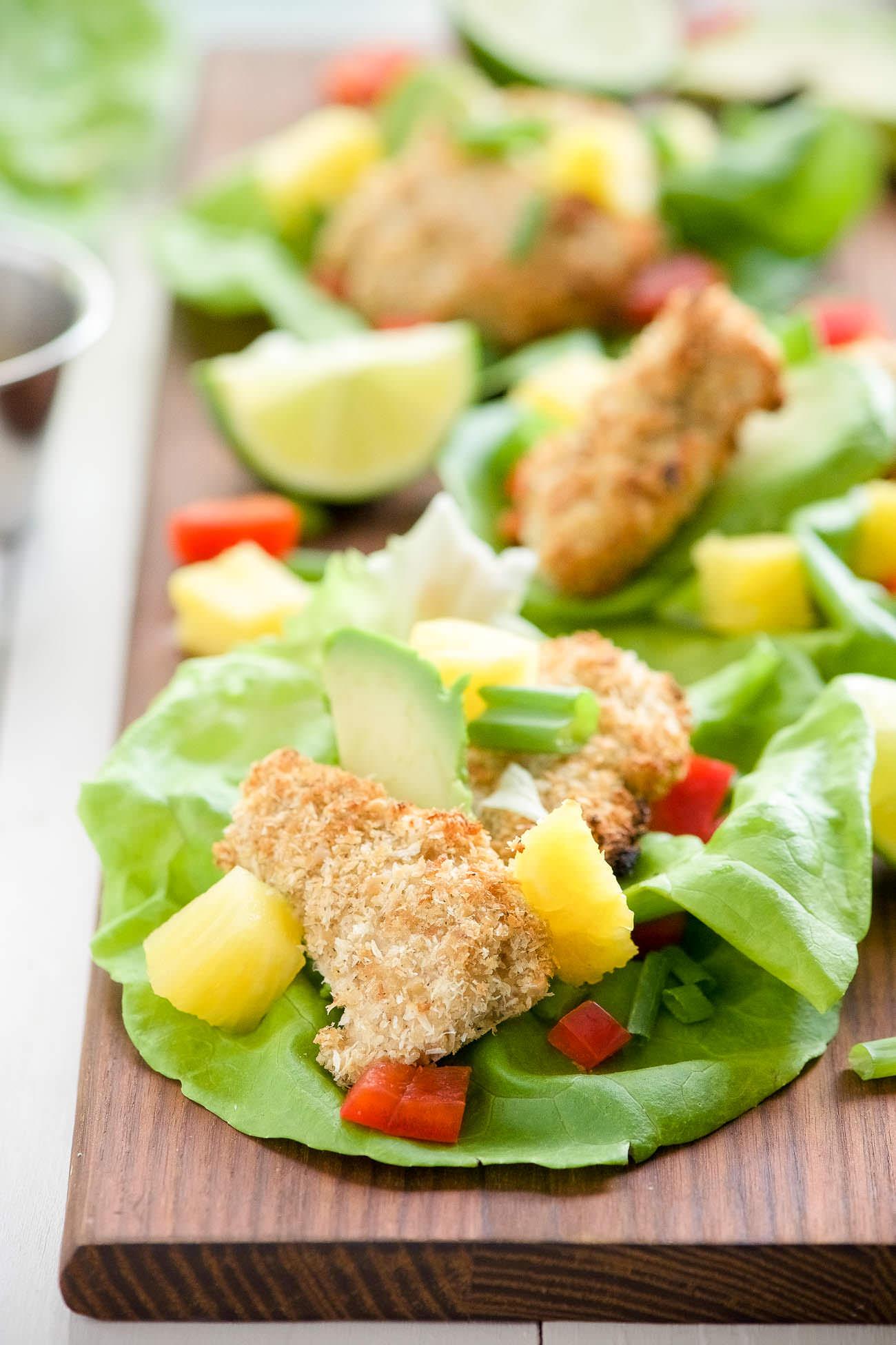 Cashew Coconut Crusted Chicken Lettuce Wraps are our new favorite hand held dinner! Every bite of chicken is encrusted in crunchy cashews and coconut then drizzled with a sweet and spicy Ancho Honey Mustard Sauce!