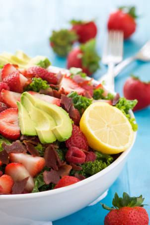 This Bacon & Berry Kale Salad with Honey Lemon Vinaigrette is a summertime superfood salad! Fresh kale tossed in a honey lemon vinaigrette and topped with fresh berries, creamy avocado, and crispy bacon!
