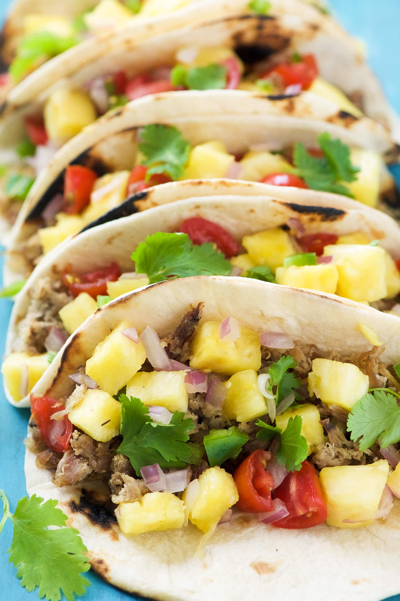 Hawaiian BBQ Pork Tacos are filled with crispy, spiced pork and topped with an irresistible and juicy Pineapple Pico de Gallo! The ideal summer street taco! 
