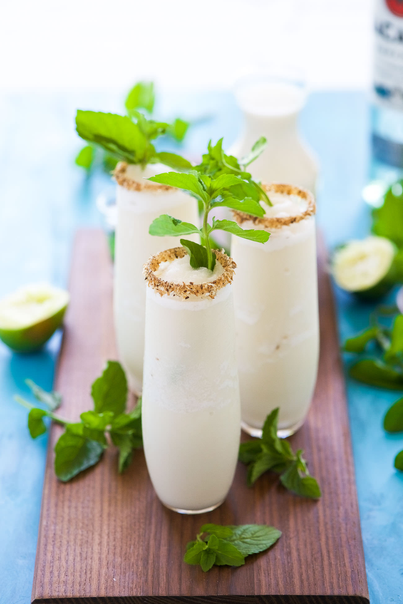 This Toasted Frozen Coconut Mojito is a summer must have! Made lighter with fresh lime juice, a mint simple syrup, and then blended with coconut milk for a refreshing cocktail that you won't have trouble asking for seconds!