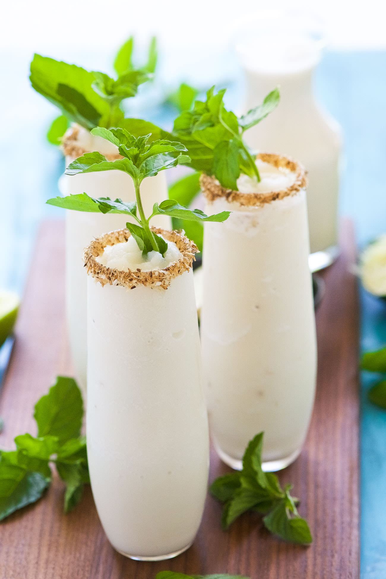 This Toasted Frozen Coconut Mojito is a summer must have! Made lighter with fresh lime juice, a mint simple syrup, and then blended with coconut milk for a refreshing cocktail that you won't have trouble asking for seconds!