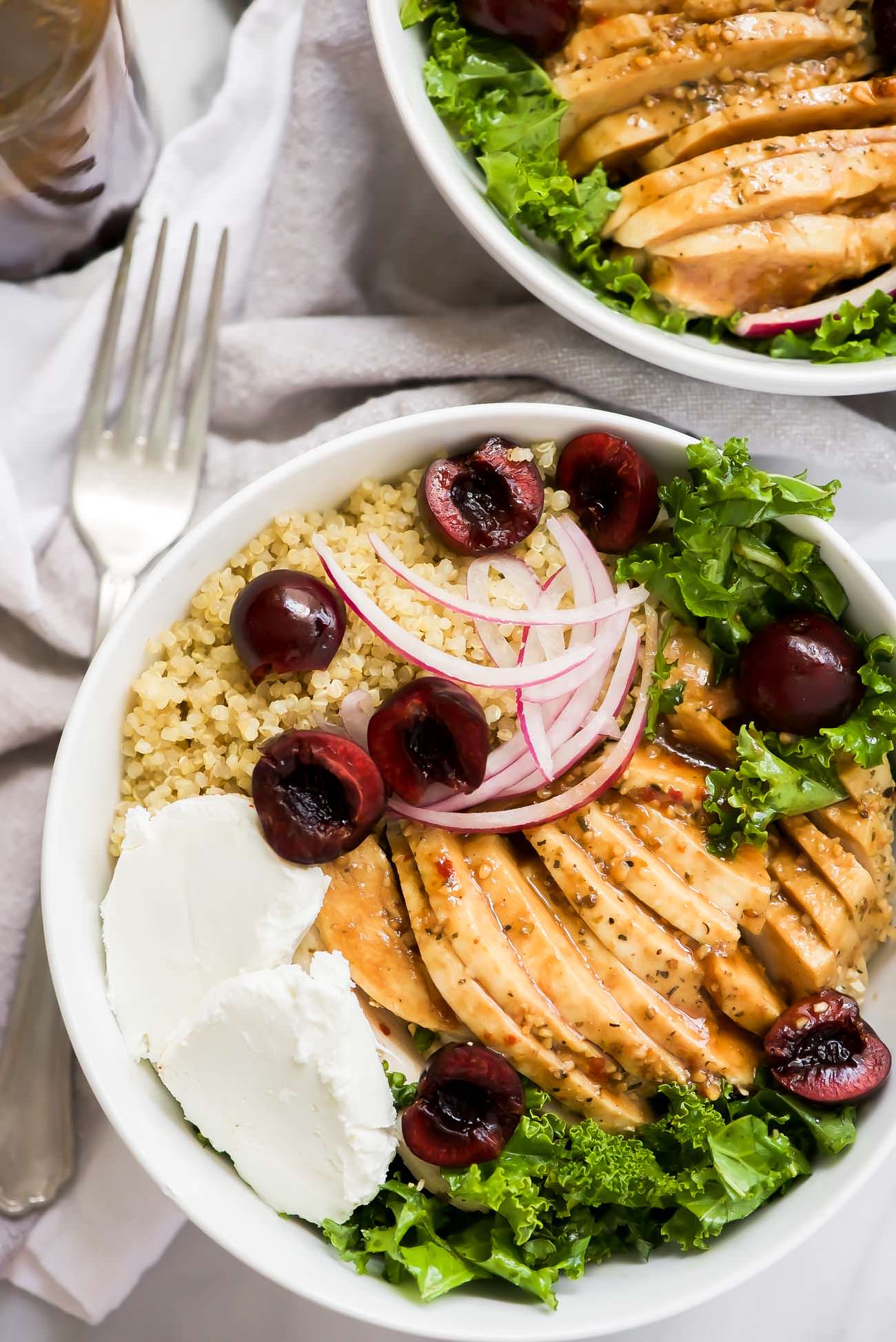 Honey Balsamic Glazed Chicken Quinoa Bowls are a hearty and flavor meal! Juicy chicken is coated in a sticky, sweet balsamic glaze then paired with fluffy quinoa, creamy goat cheese, and fresh cherries. A perfect make ahead meal!