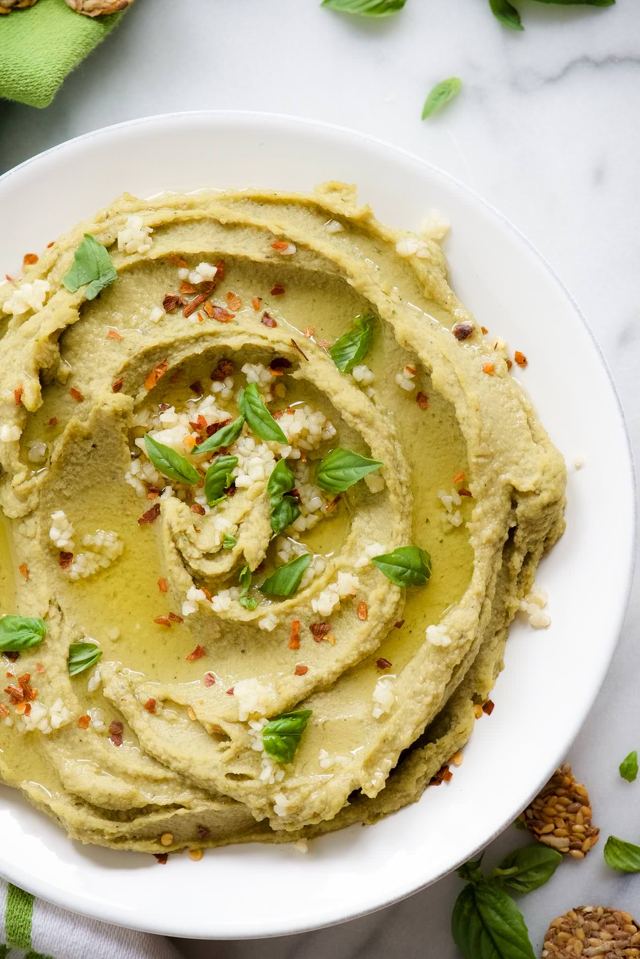 Spicy Basil Hummus is so delicious and with only 7 ingredients, it couldn't be easier to make! Fresh basil, chickpeas and a touch of red pepper take this classic hummus up a few notches!