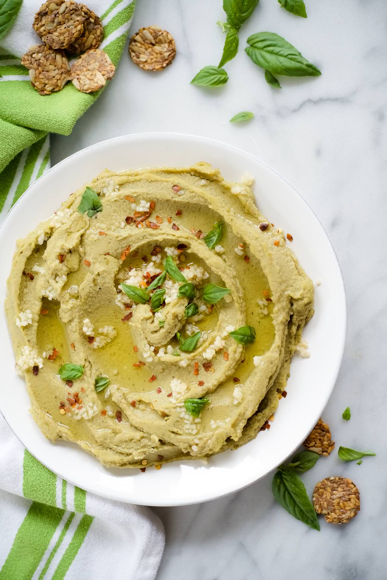 Spicy Basil Hummus is so delicious and with only 7 ingredients, it couldn't be easier to make! Fresh basil, chickpeas and a touch of red pepper take this classic hummus up a few notches!