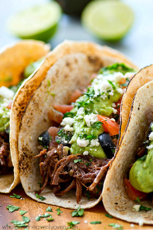 Kicked up chipotle crockpot beef tacos piled high with a fresh greek salsa and the most amazing avocado crema ever! Meet your new favorite taco.
