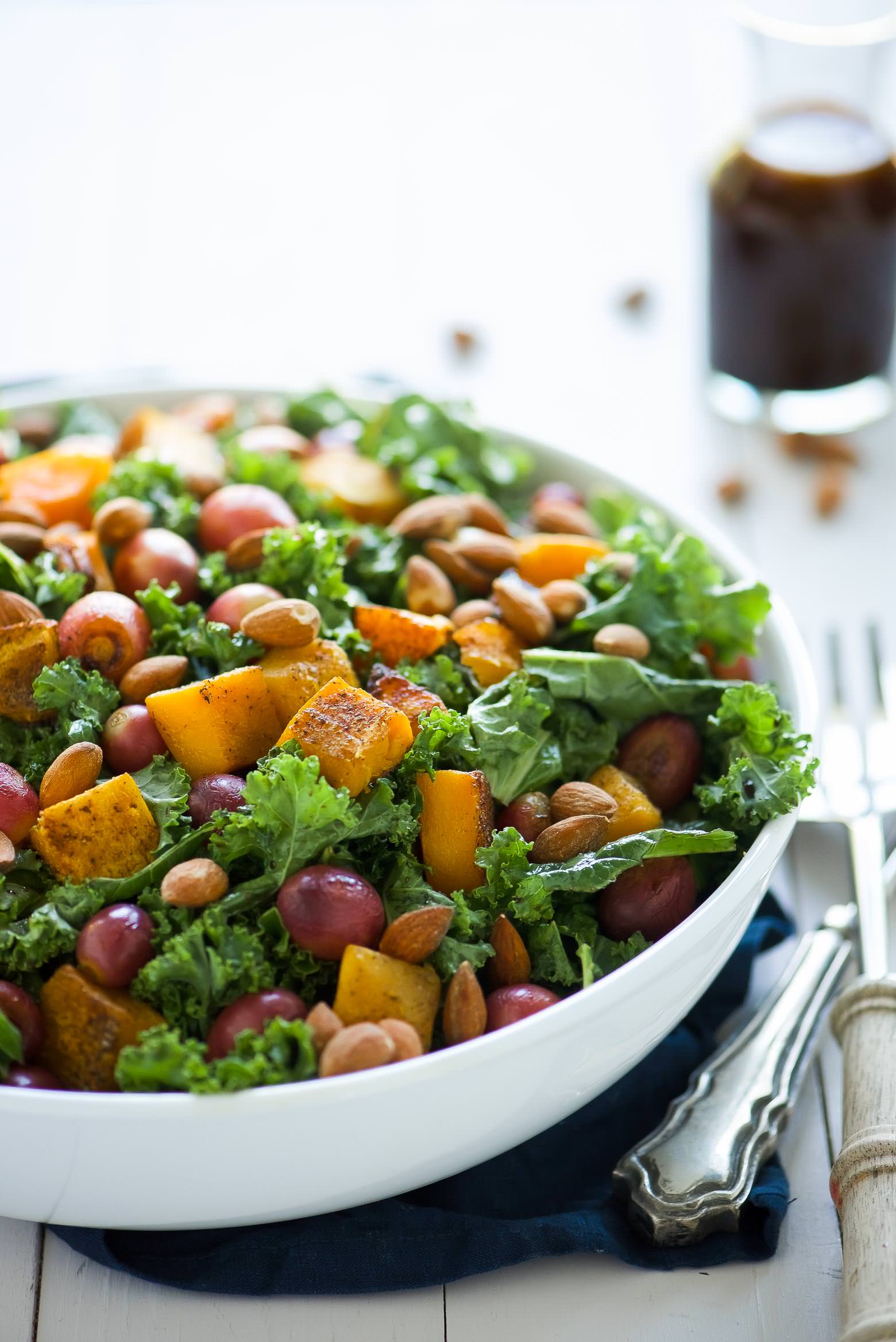Massaged Kale Salad with Butternut Squash and Roasted Grapes is fall in a dish! It is healthy, simple and perfect for make-ahead lunches! Caramelized butternut squash and roasted grapes mix with balsamic massaged kale for a paleo and vegan friendly salad!