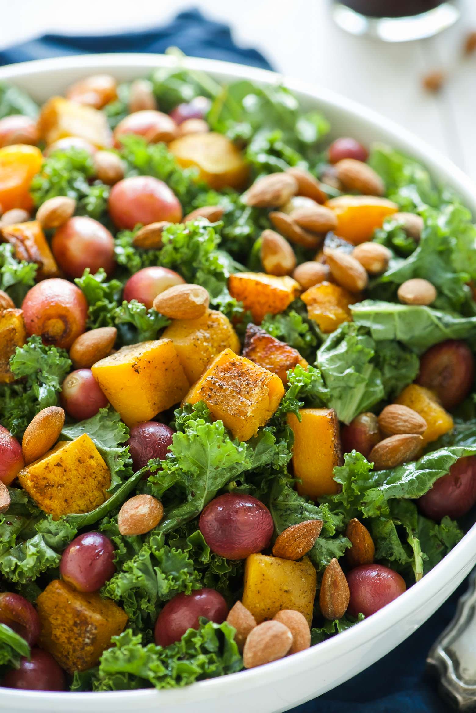 Massaged Kale Salad with Butternut Squash and Roasted Grapes is fall in a dish! It is healthy, simple and perfect for make-ahead lunches! Caramelized butternut squash and roasted grapes mix with balsamic massaged kale for a paleo and vegan friendly salad!