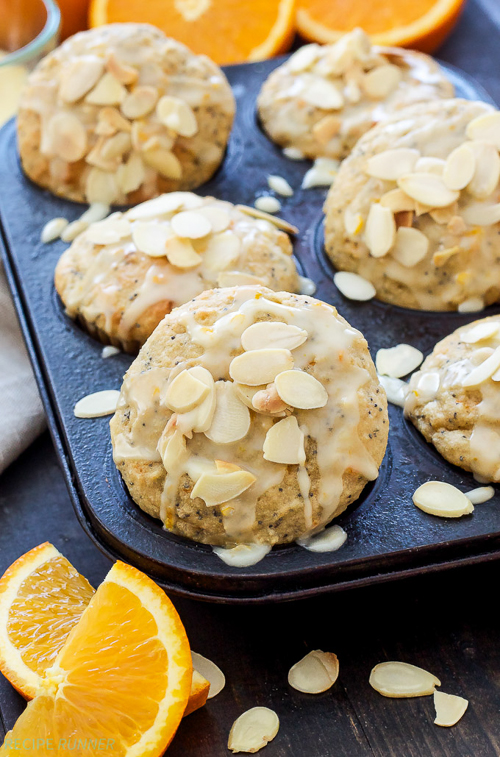 Light, tender Orange Almond Poppy Seed Muffins are perfect for your weekend breakfast or brunch! Full of fresh orange zest, two wholesome flours, poppy seeds, almond extract and topped with a sweet orange glaze for a decadent finishing touch!